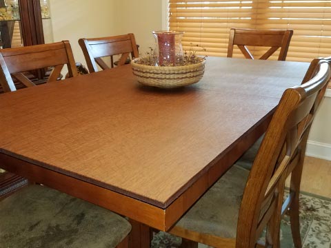 Dining room table pad protecting table from candle centerpiece, in medium cherry woodgrain